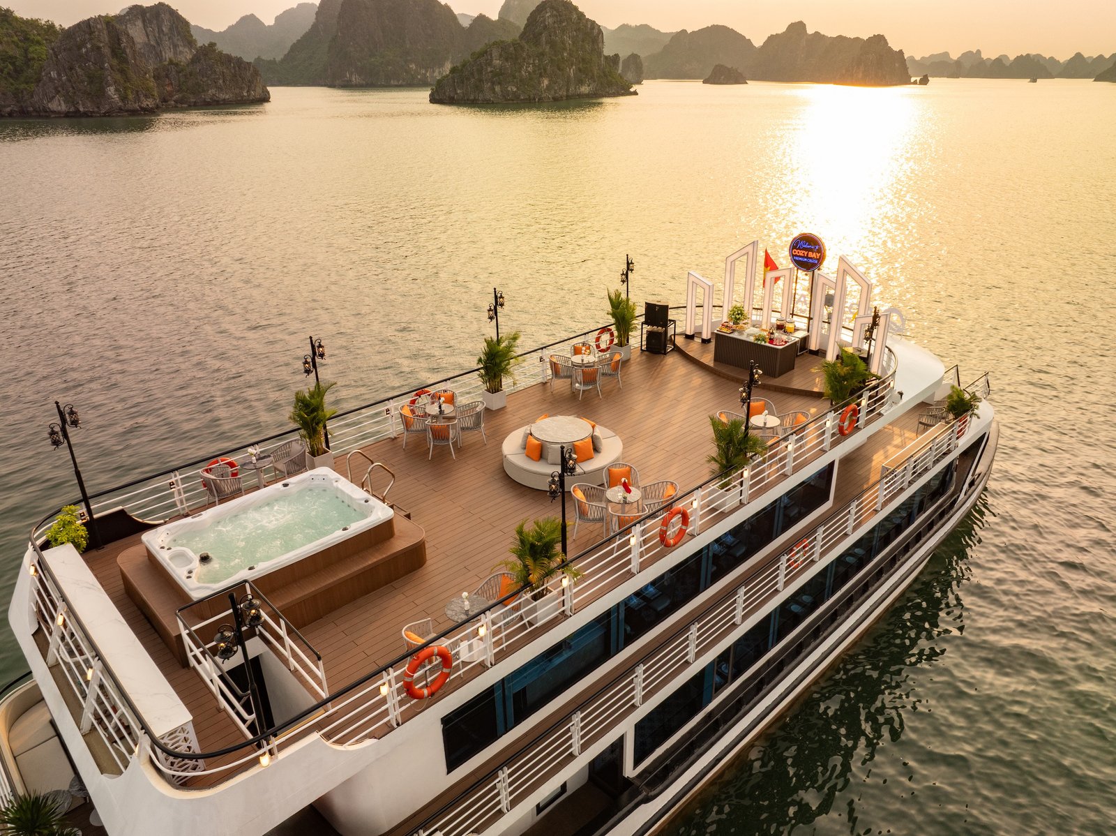Jacuzzi en la cubierta de sol del Cozy Bay Premium al atardecer con los karst de la Bahía de Halong