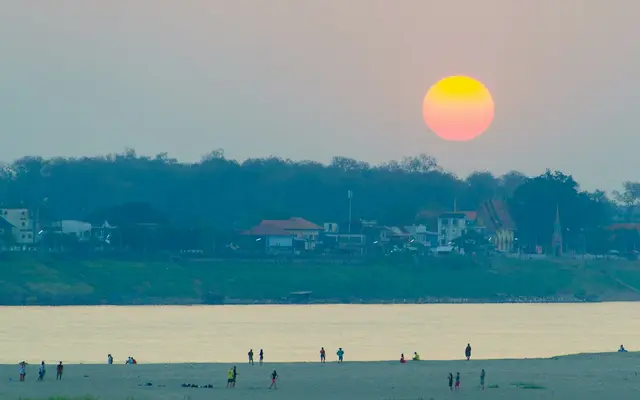 A red sun rising low over the river