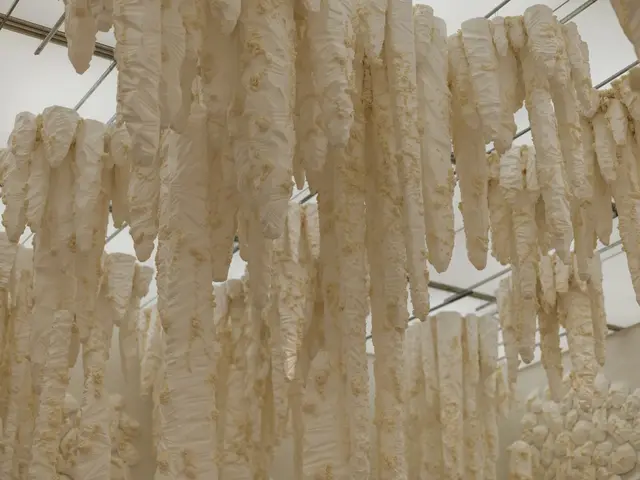 Fresh rice noodles hanging to dry at a family workshop