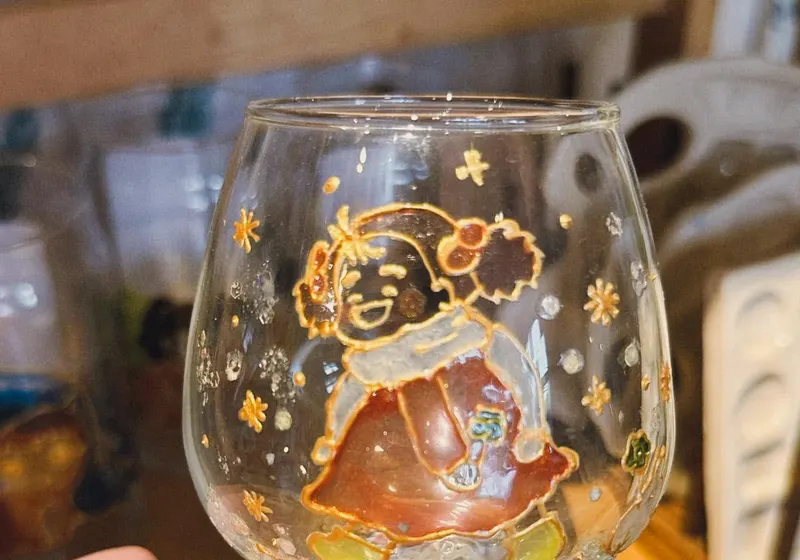 Isang pintadong wine glass na natapos sa ginto at pula