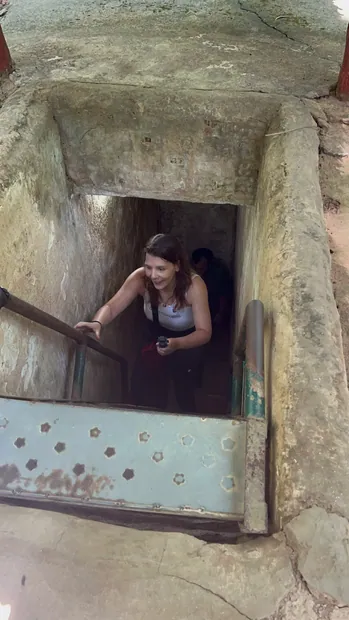 Climbing out of an original Củ Chi tunnel entrance