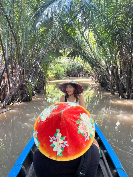 Rowing boat gliding beneath a canopy of water coconut palms