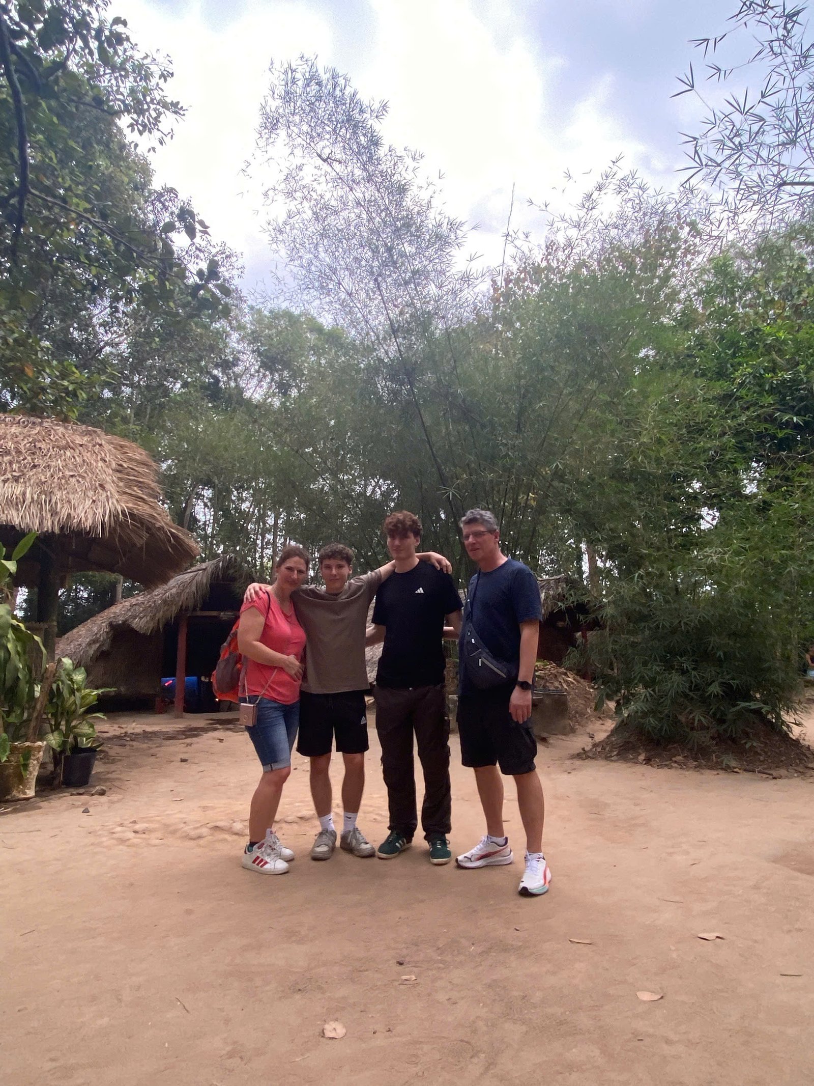 By a traditional guerrilla-era hut in the Cu Chi jungle
