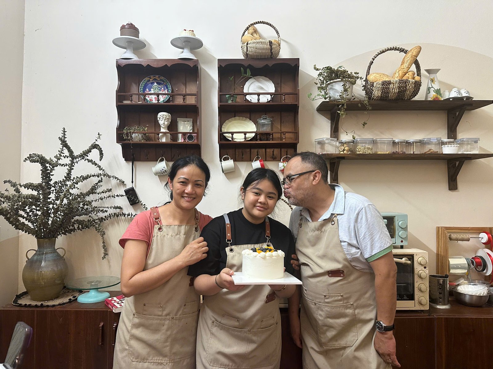 Guests posing with their finished birthday cake at the workshop in Hanoi