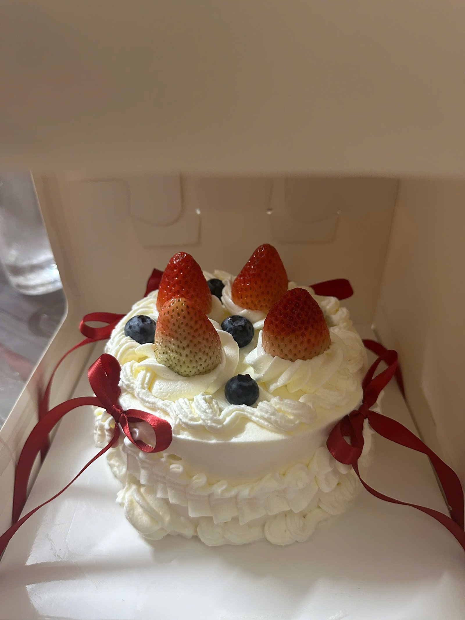 Finished birthday cake decorated with strawberries and blueberries