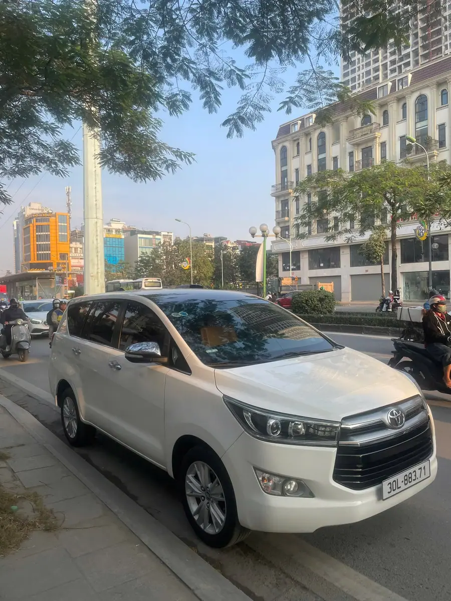 A white Toyota Innova waiting on a Hanoi street