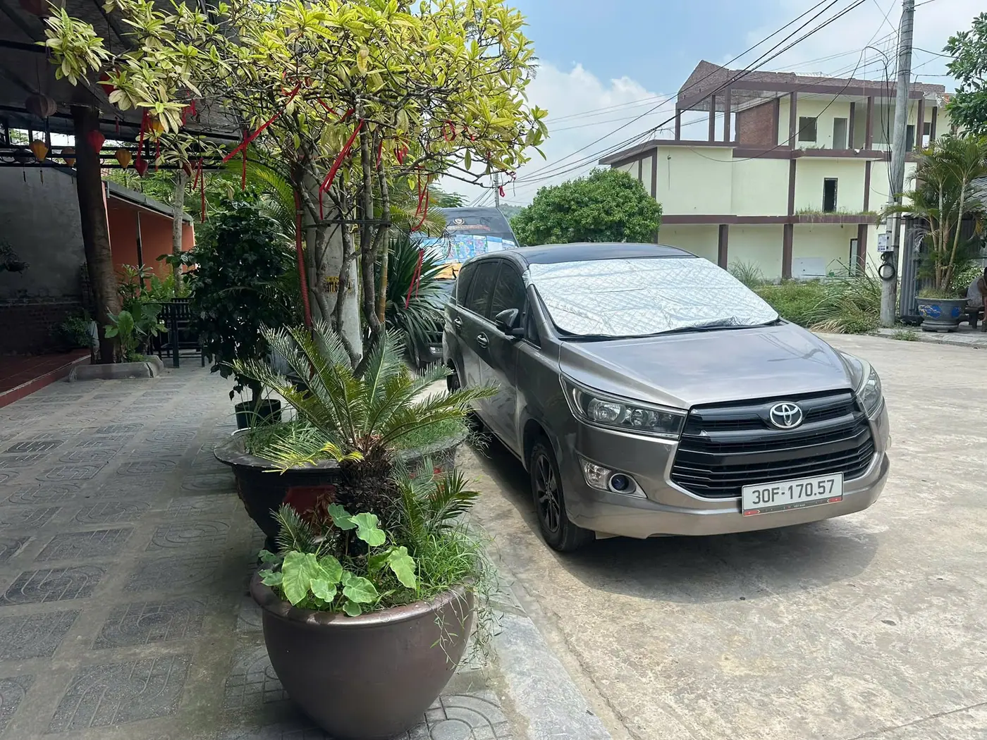 A grey Toyota Innova seven-seater waiting in a hotel courtyard