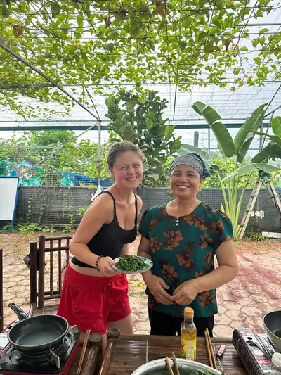 A local host showing a guest the beans just picked from the garden