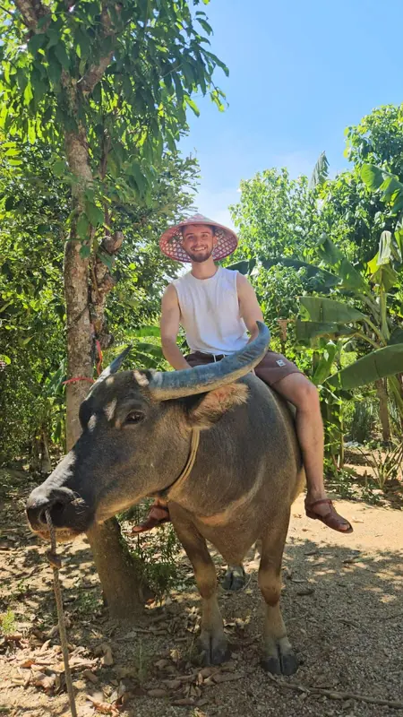 Guest riding a water buffalo through the farm