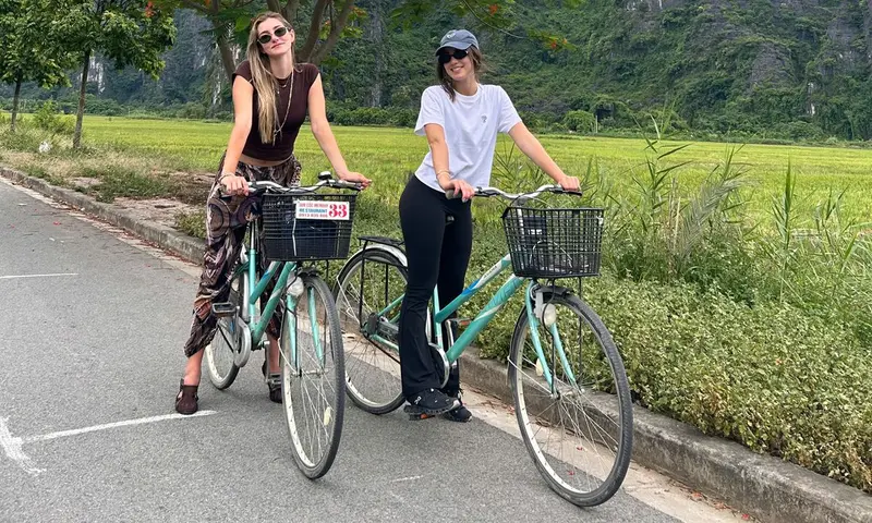 Two guests standing over Vside city bikes on a quiet, flat lane