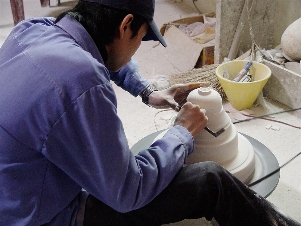 Bat Trang 陶工在作坊里用转盘修坯