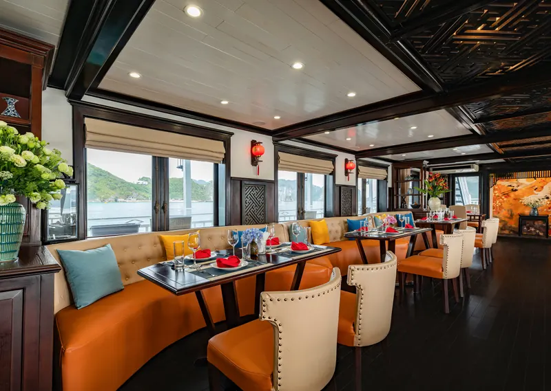 Banquette seating in the restaurant with the bay visible through wide windows behind