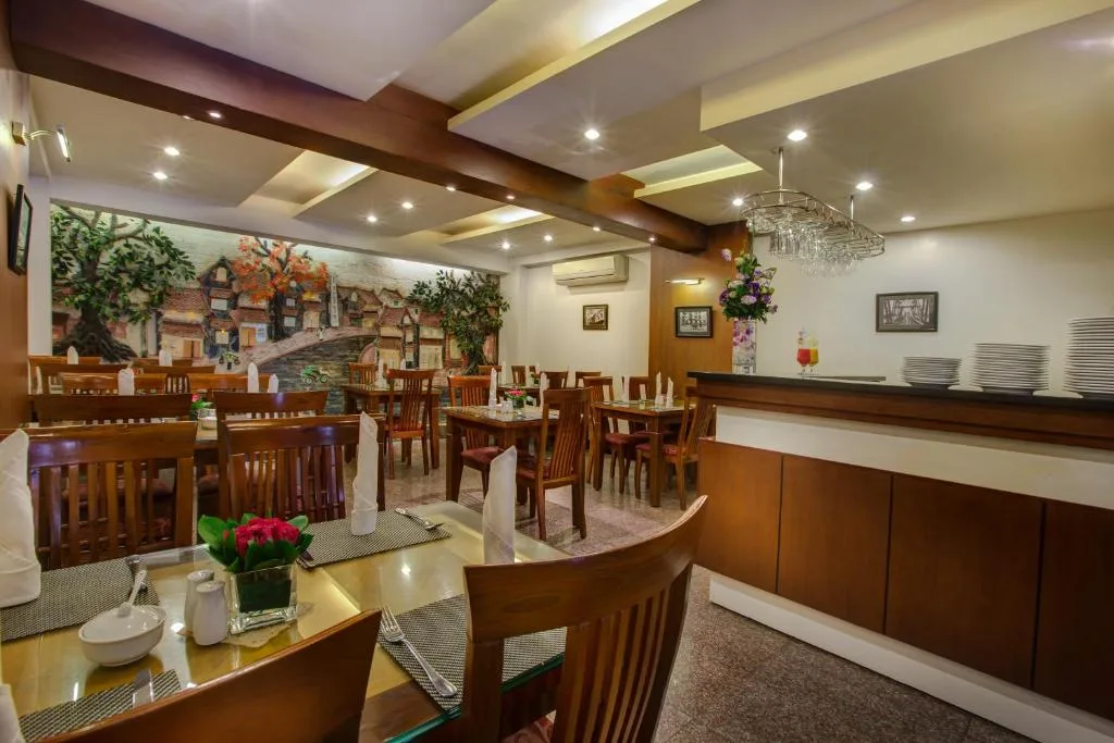 Hotel restaurant with wooden tables and a painted mural of an old street