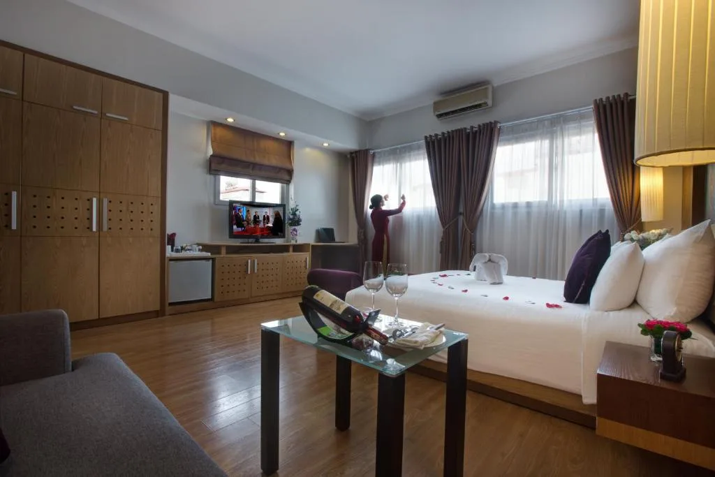 Executive Suite: the wardrobe run, a sofa and a glass table under tall curtained windows