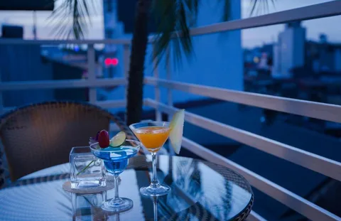 Junior Suite: drinks on the balcony table at dusk, with the rooftops behind