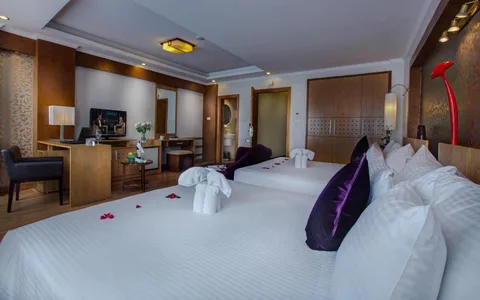 Family Suite: both beds with the desk, television and wardrobe run beyond