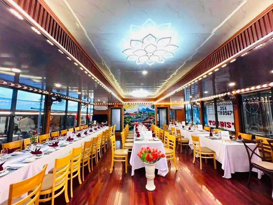 The boat saloon set for dinner under a lotus-shaped light