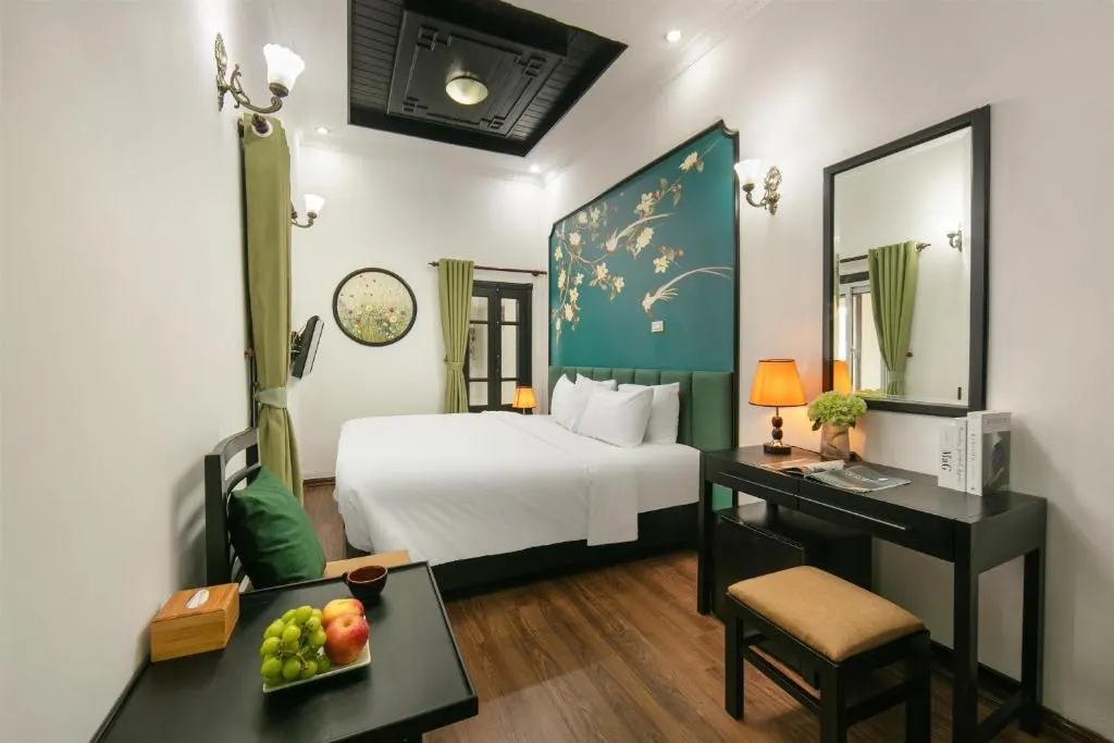 Room with a king bed, writing desk and a large mirror