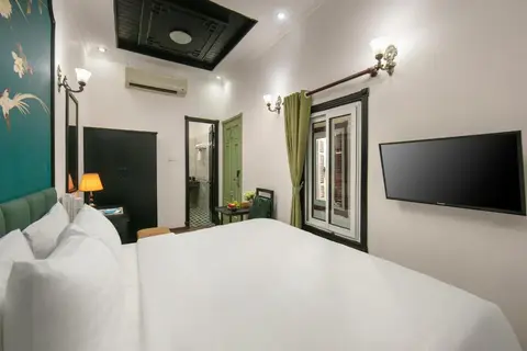 Superior room: bed, wall-mounted television and the shuttered window