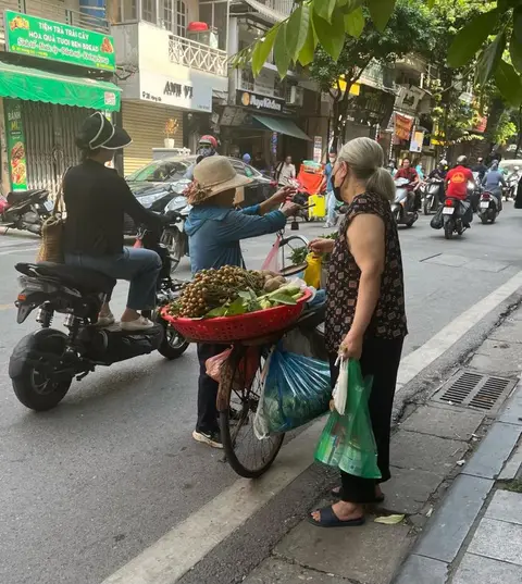 Buying longans from a bicycle vendor on the street outside